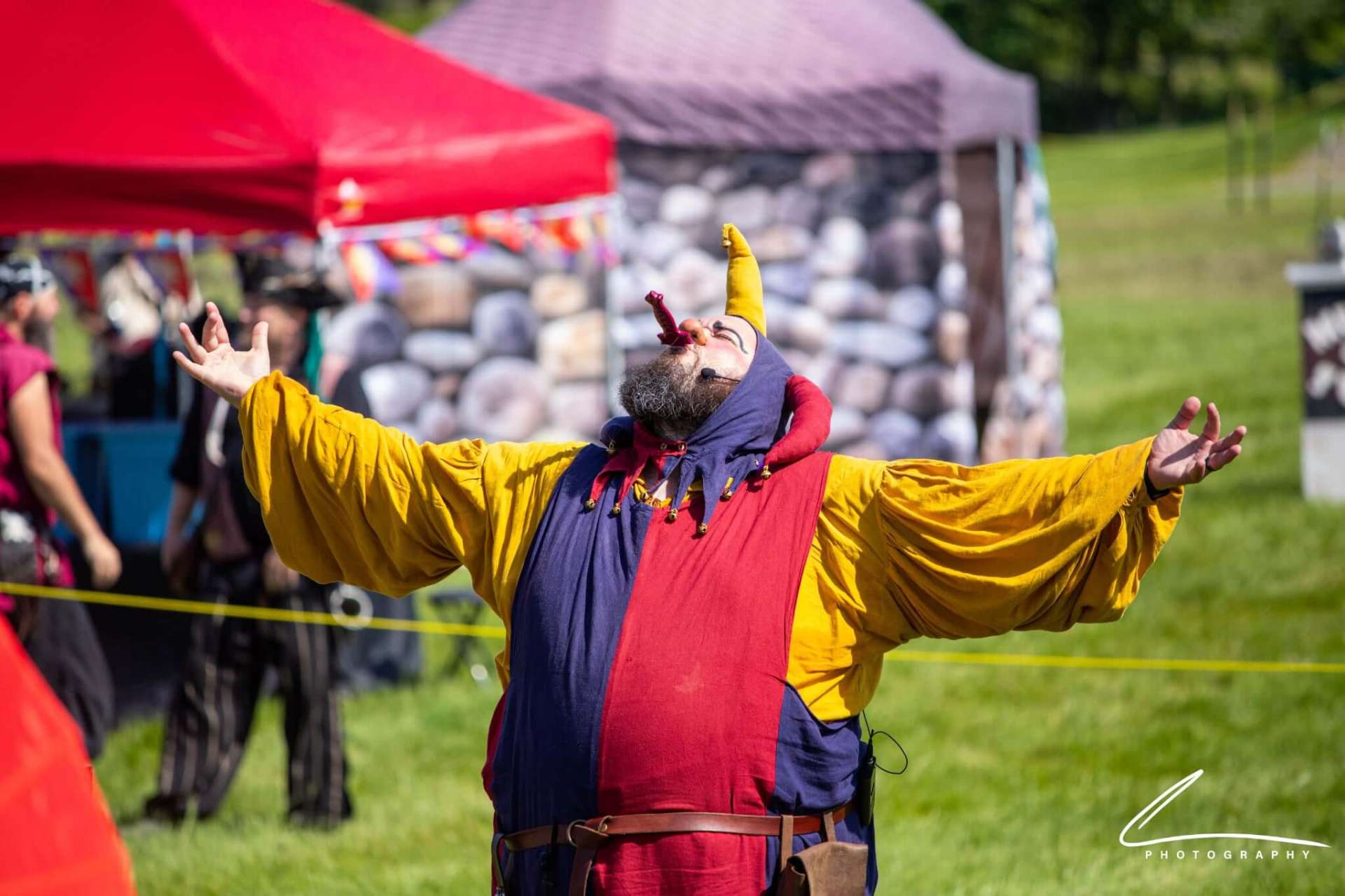 Quibbleflop with arms wide on an outdoor stage
