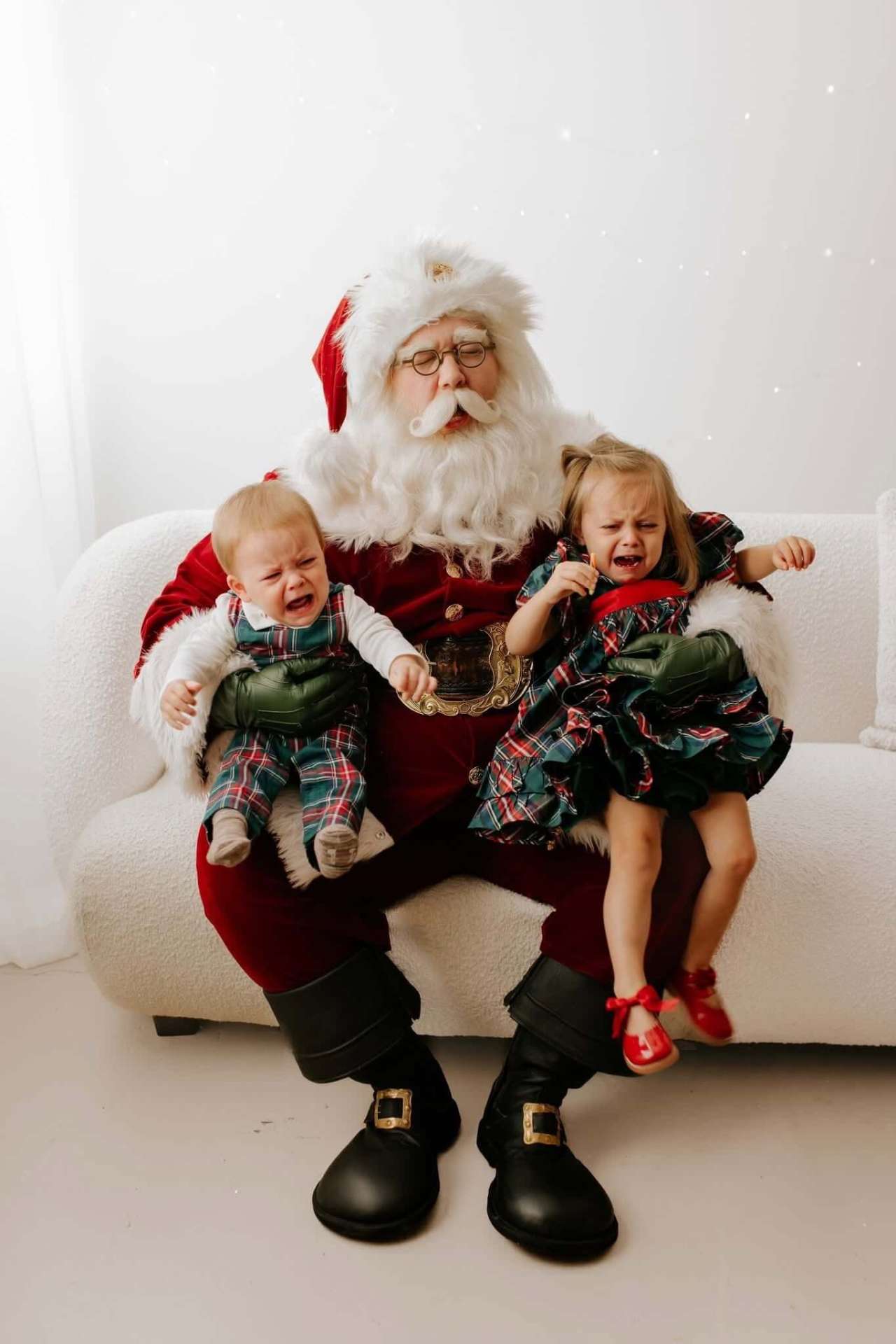 Santa keeping his cool with two crying toddlers on his lap