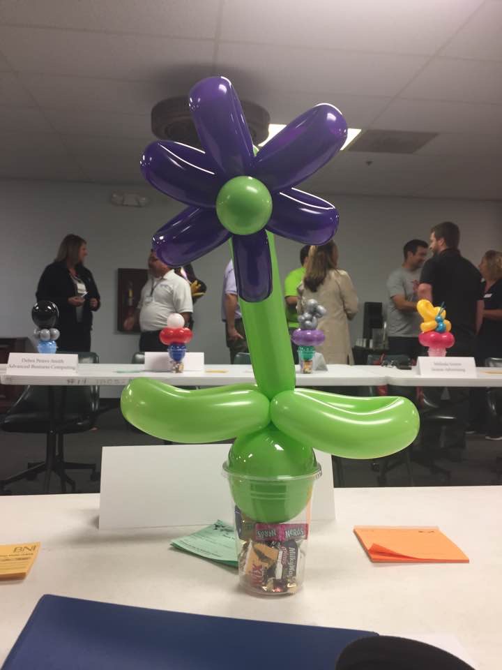 Purple and green balloon flower centerpiece on an event table