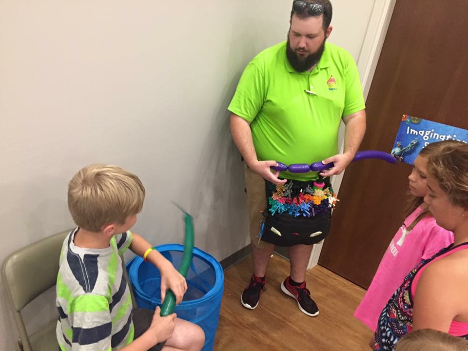 Balloon twister demonstrating a sculpture to kids