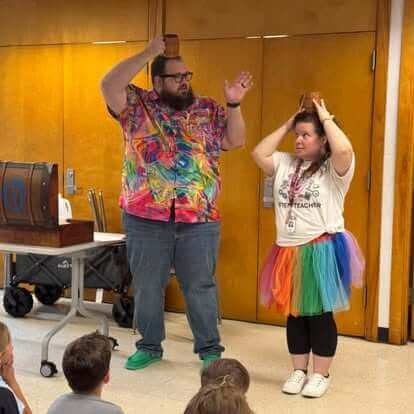 Adam performing an interactive magic trick with a teacher at a library show
