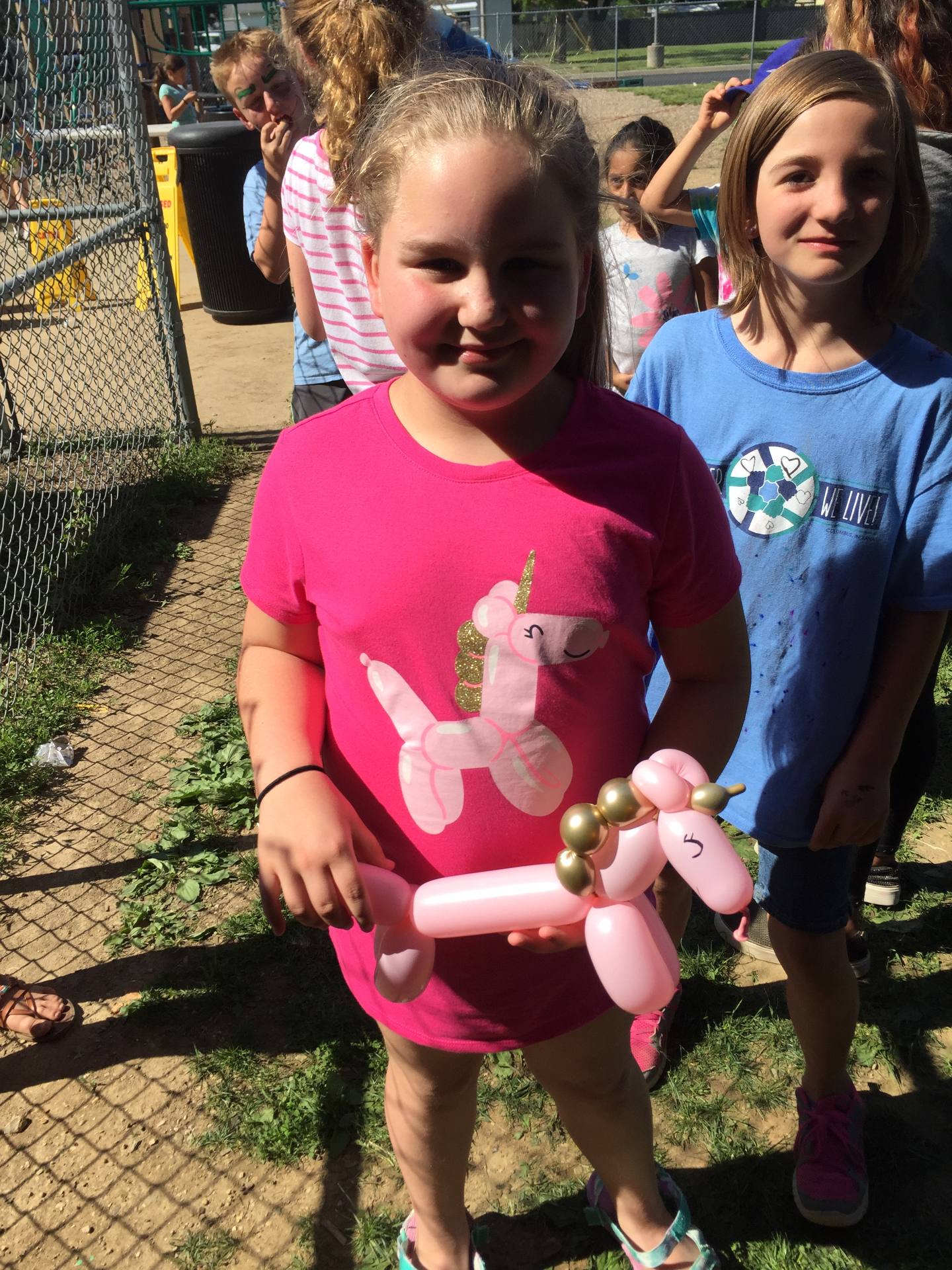 Girl holding a pink and gold balloon unicorn